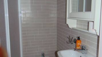 A bathroom with a shower, toilet, and sink.