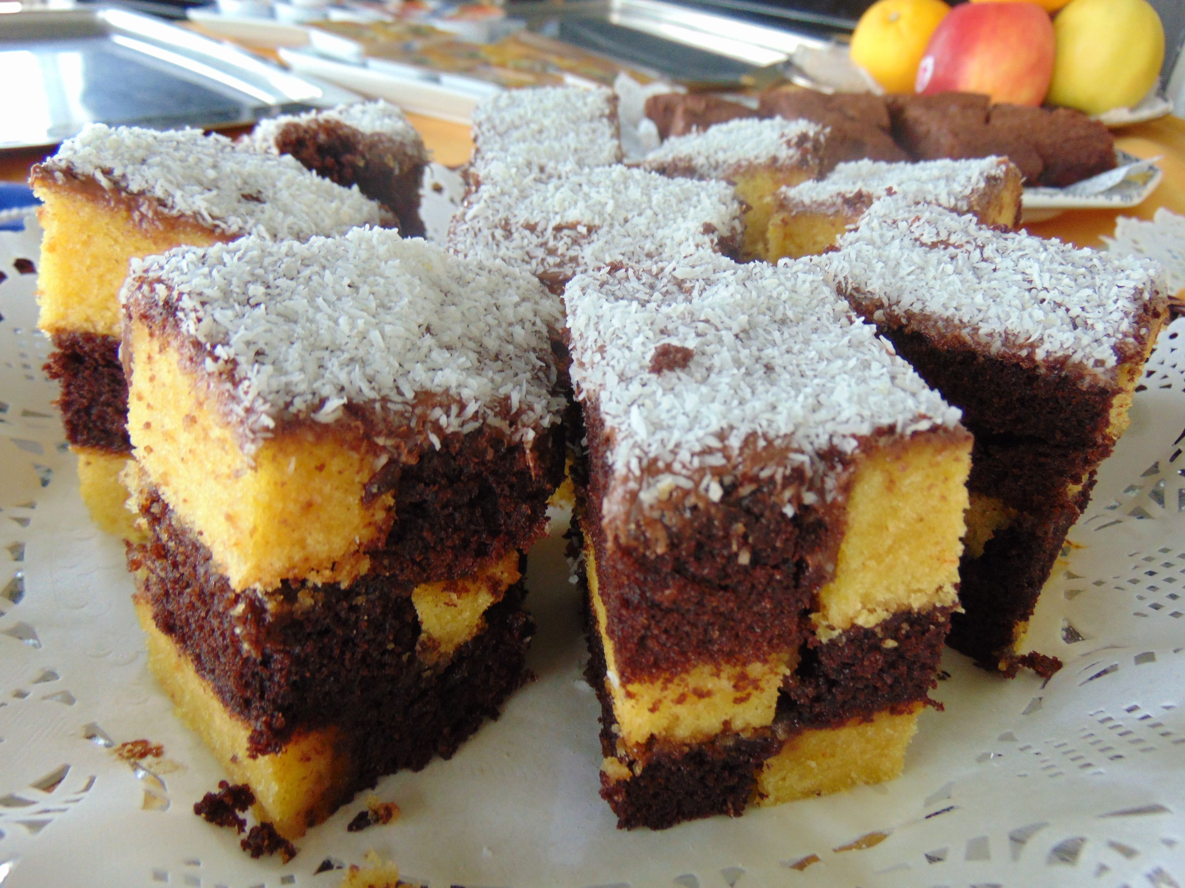 A plate of layered cake with coconut on top.