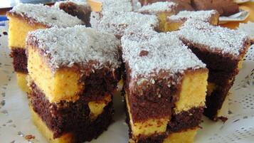 A plate of layered cake with coconut on top.