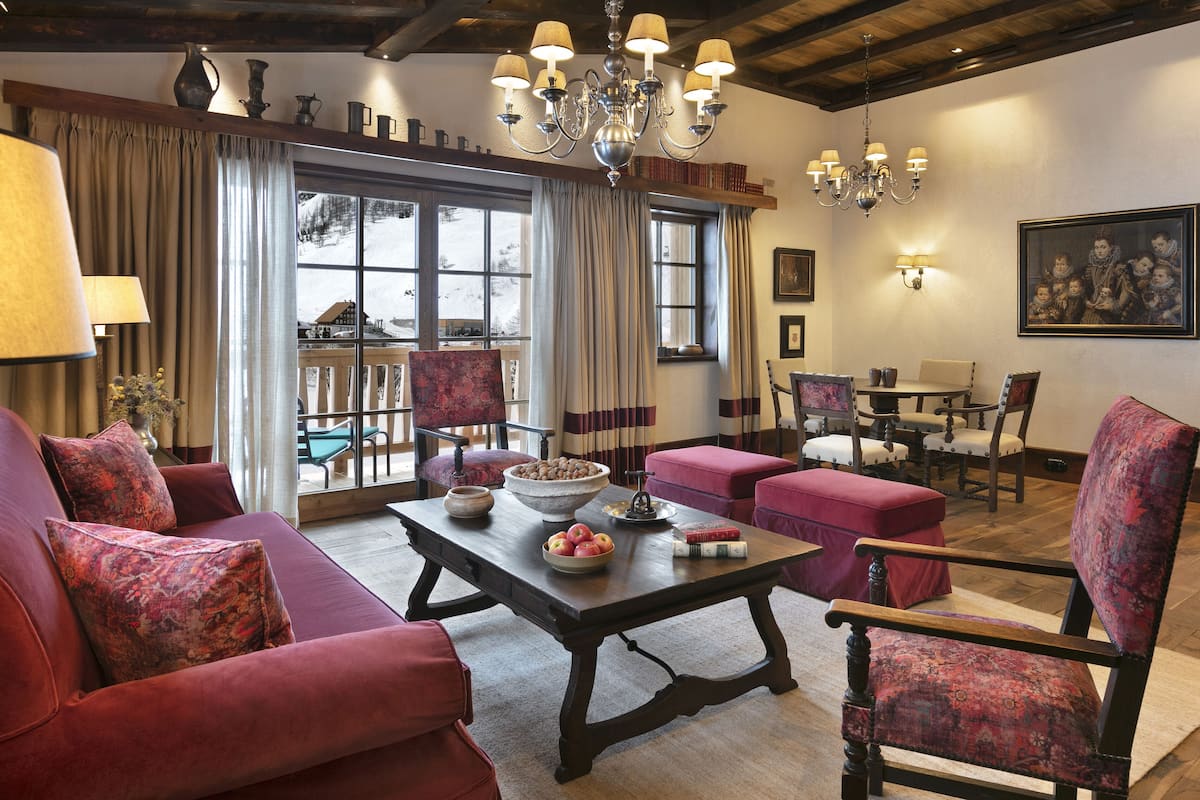 A cozy living room with a fireplace, a dining area, and a view of the outdoors.