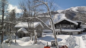 En snötäckt byggnad med ett stort garage och en skidlift.