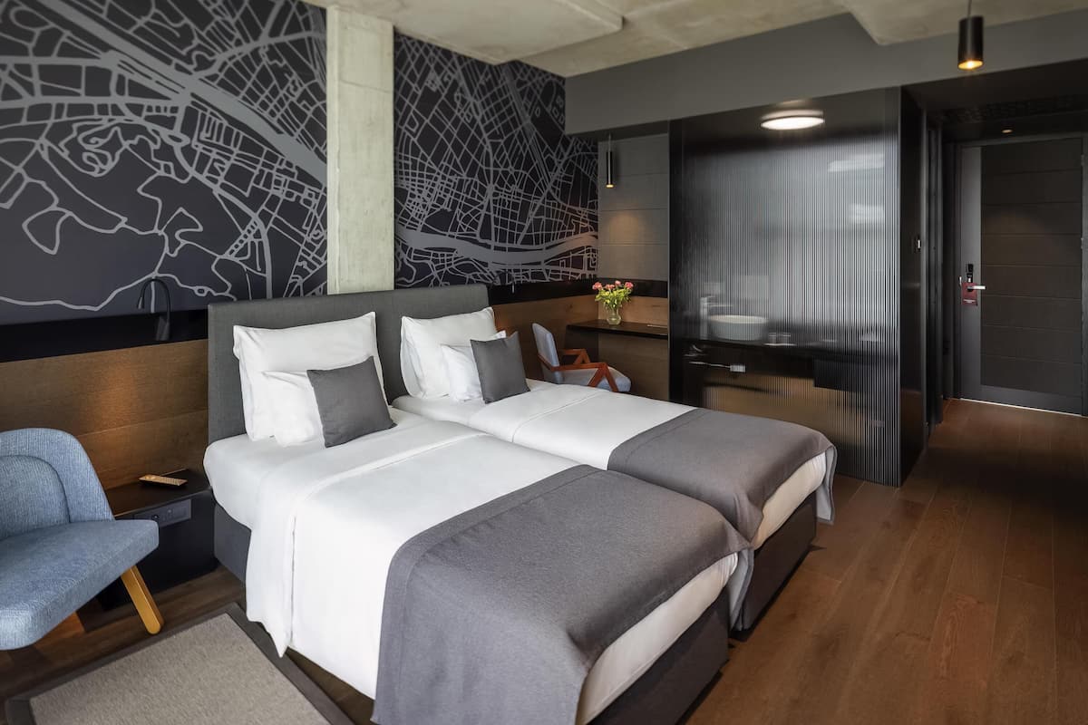 Een moderne hotelkamer met een groot bed, een bureau en een stoel.