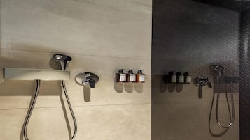A modern shower area with a handheld showerhead, a wall-mounted faucet, and a series of toiletries.