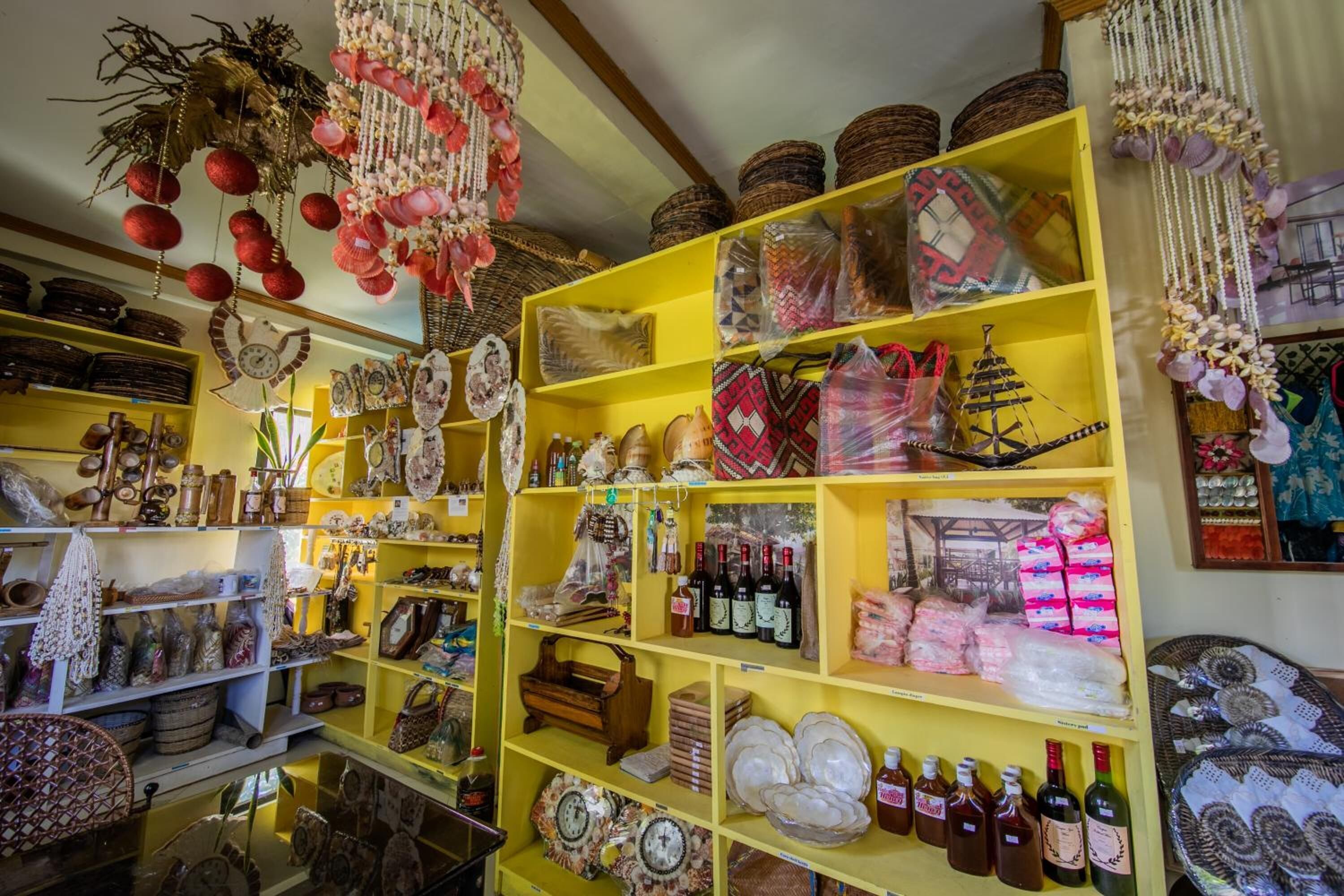 Un magasin dont les étagères sont remplies de divers articles, notamment des paniers, des paniers tressés et des objets décoratifs.