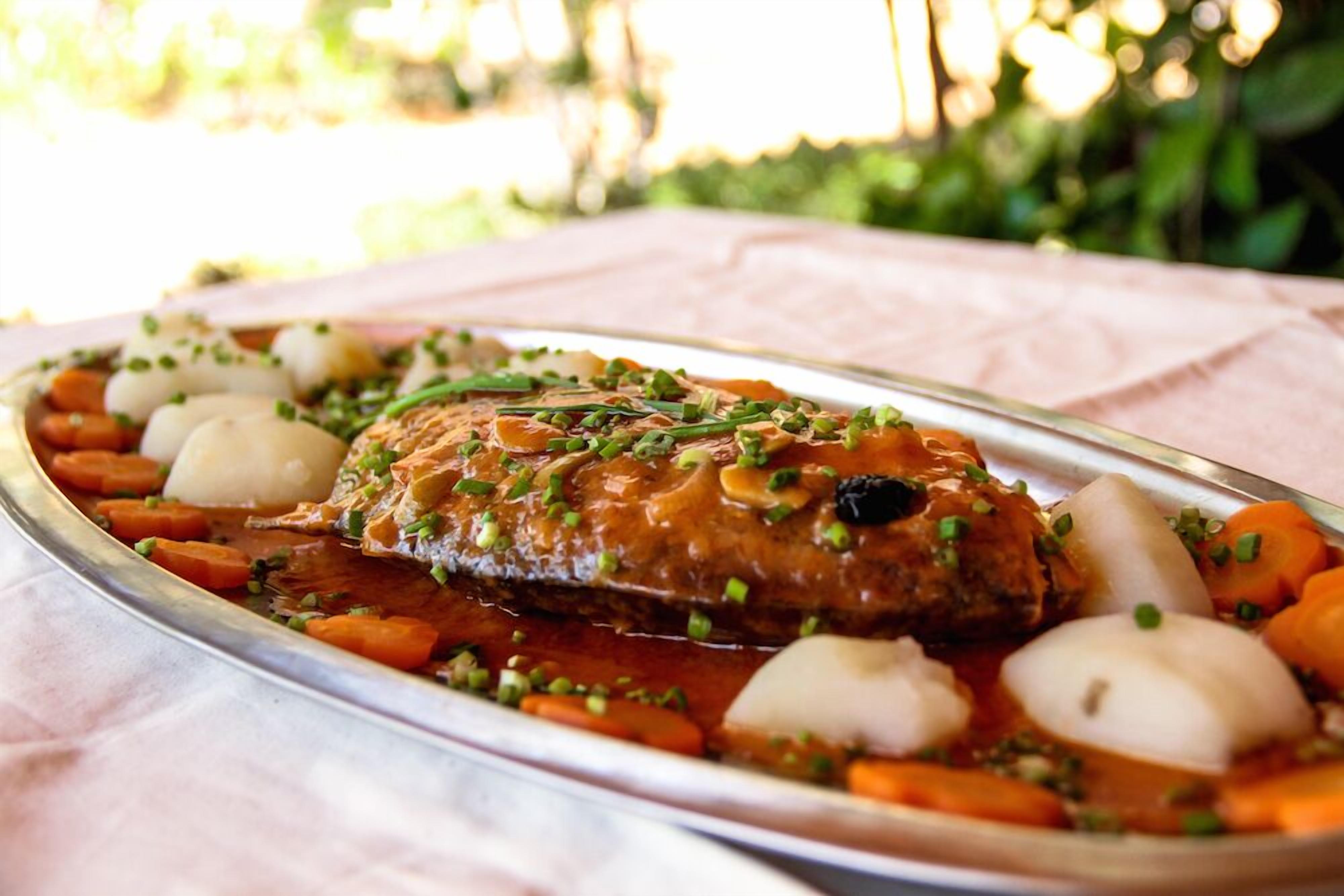 A roasted chicken with vegetables on a tray.