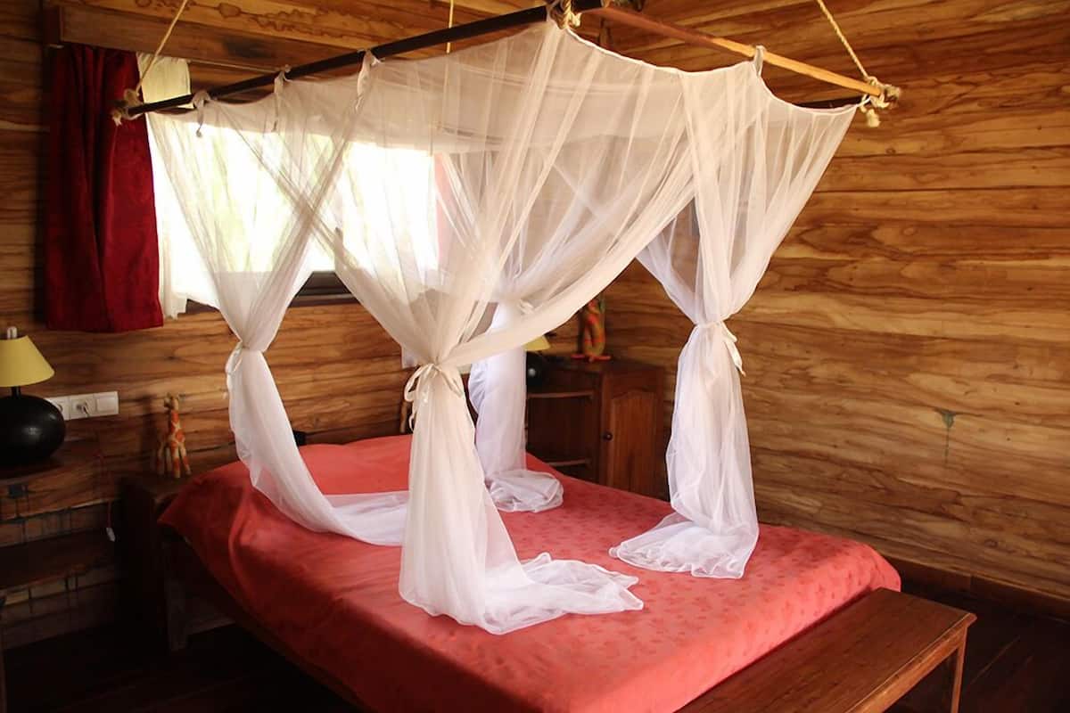 Una habitación con una cama bajo un dosel blanco.