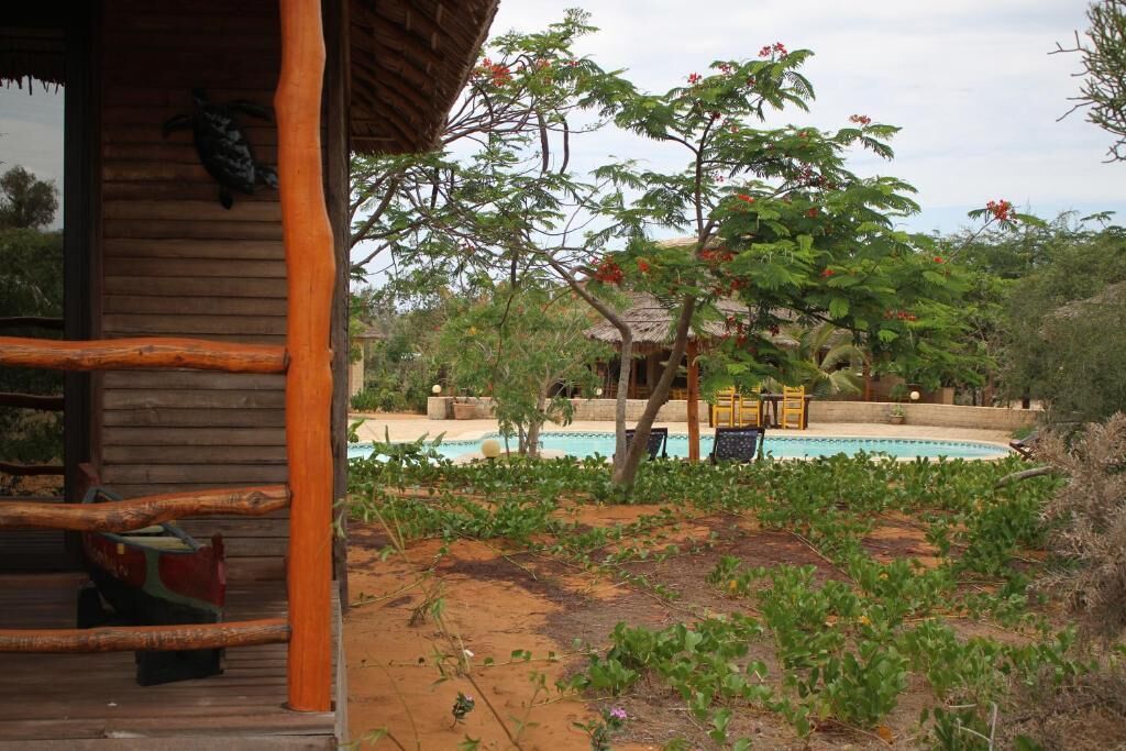 A wooden cabin with a pool and outdoor seating.