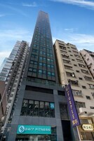 Un edificio alto con gimnasio abierto las 24 horas en la planta baja.