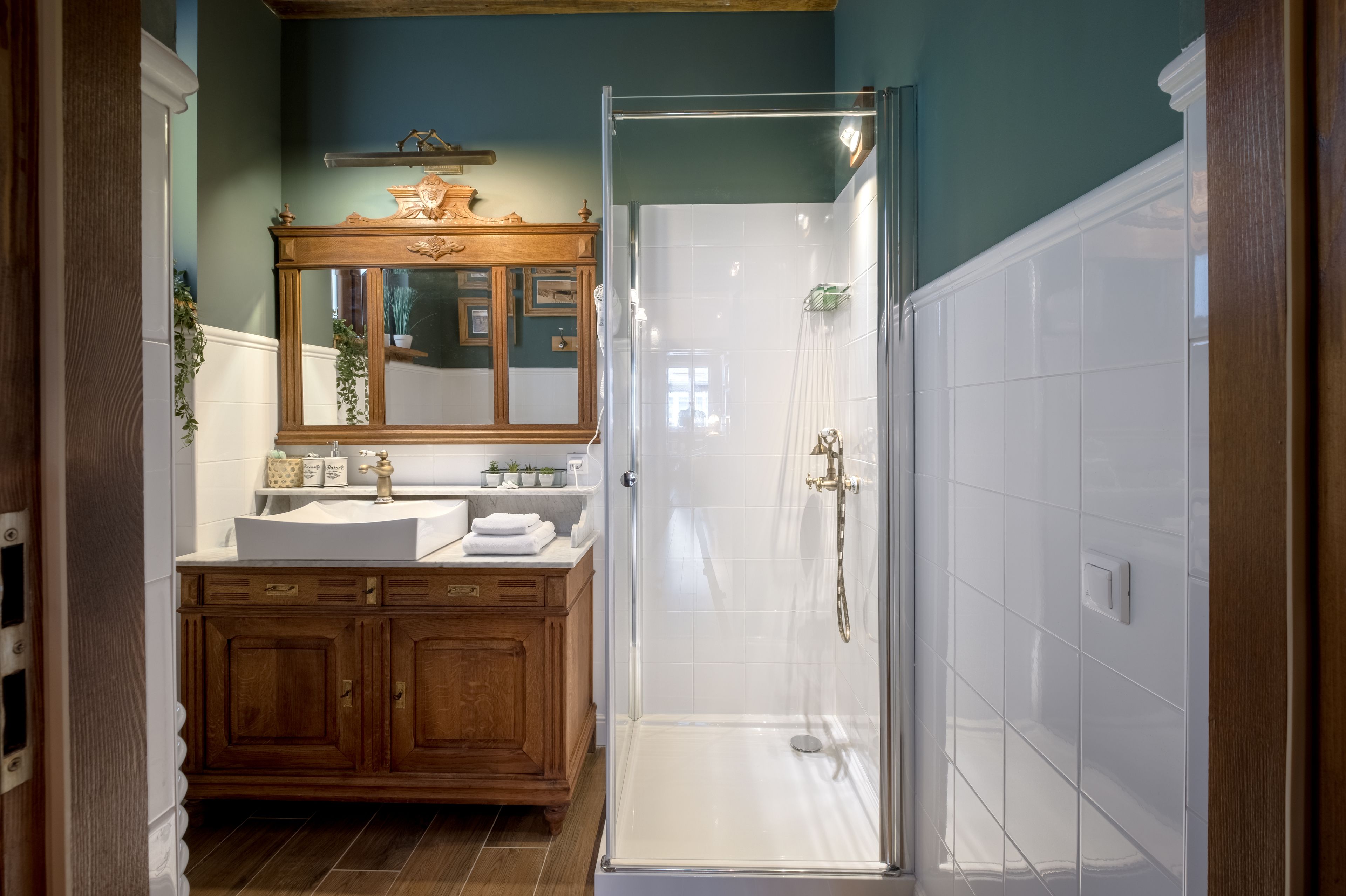 Un bagno con un mobile bagno in legno, uno specchio grande e una cabina doccia.
