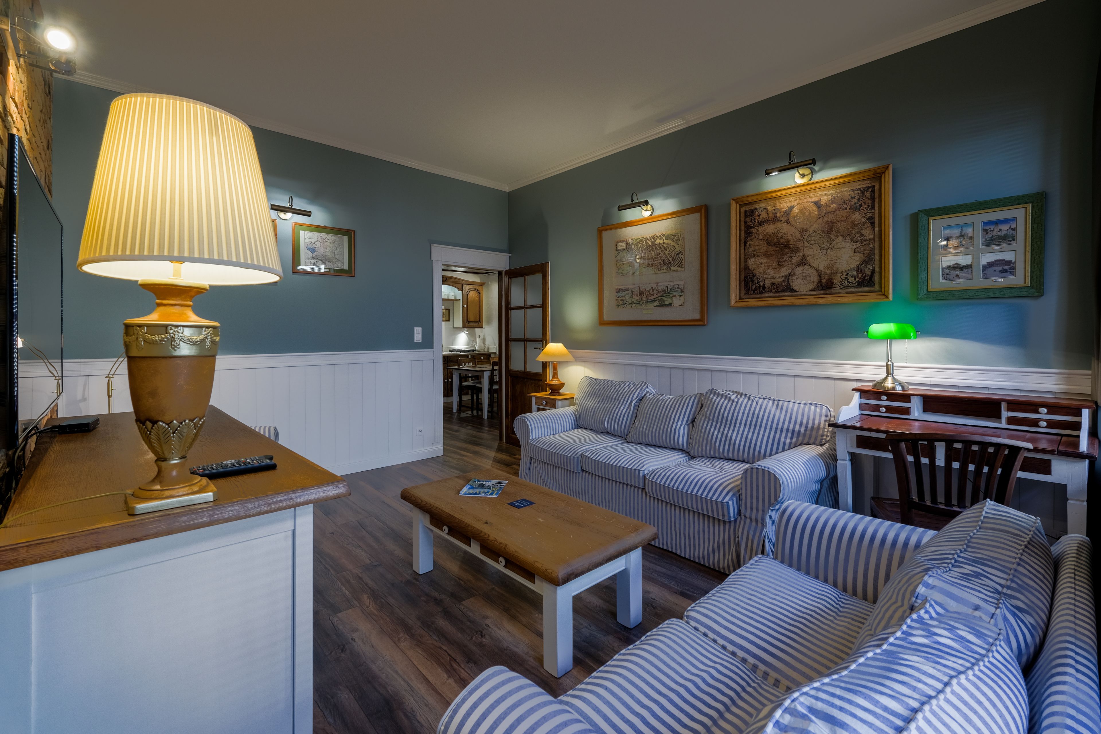 A living room with striped sofas, a wooden coffee table, and a lamp.