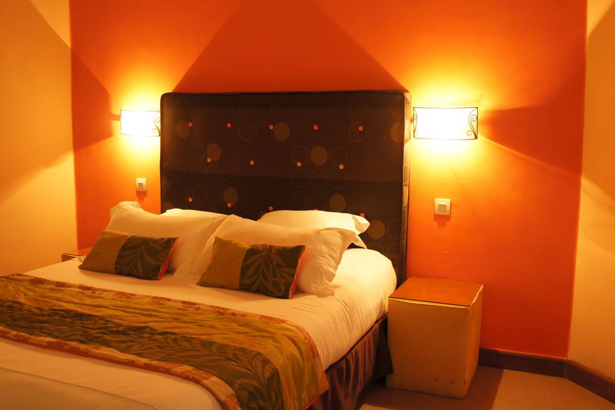 Une chambre d’hôtel avec un grand lit, deux lampes de chevet et une table de nuit.