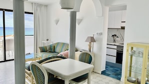 Una sala de estar moderna con un sofá, una mesa de comedor y una zona de cocina.