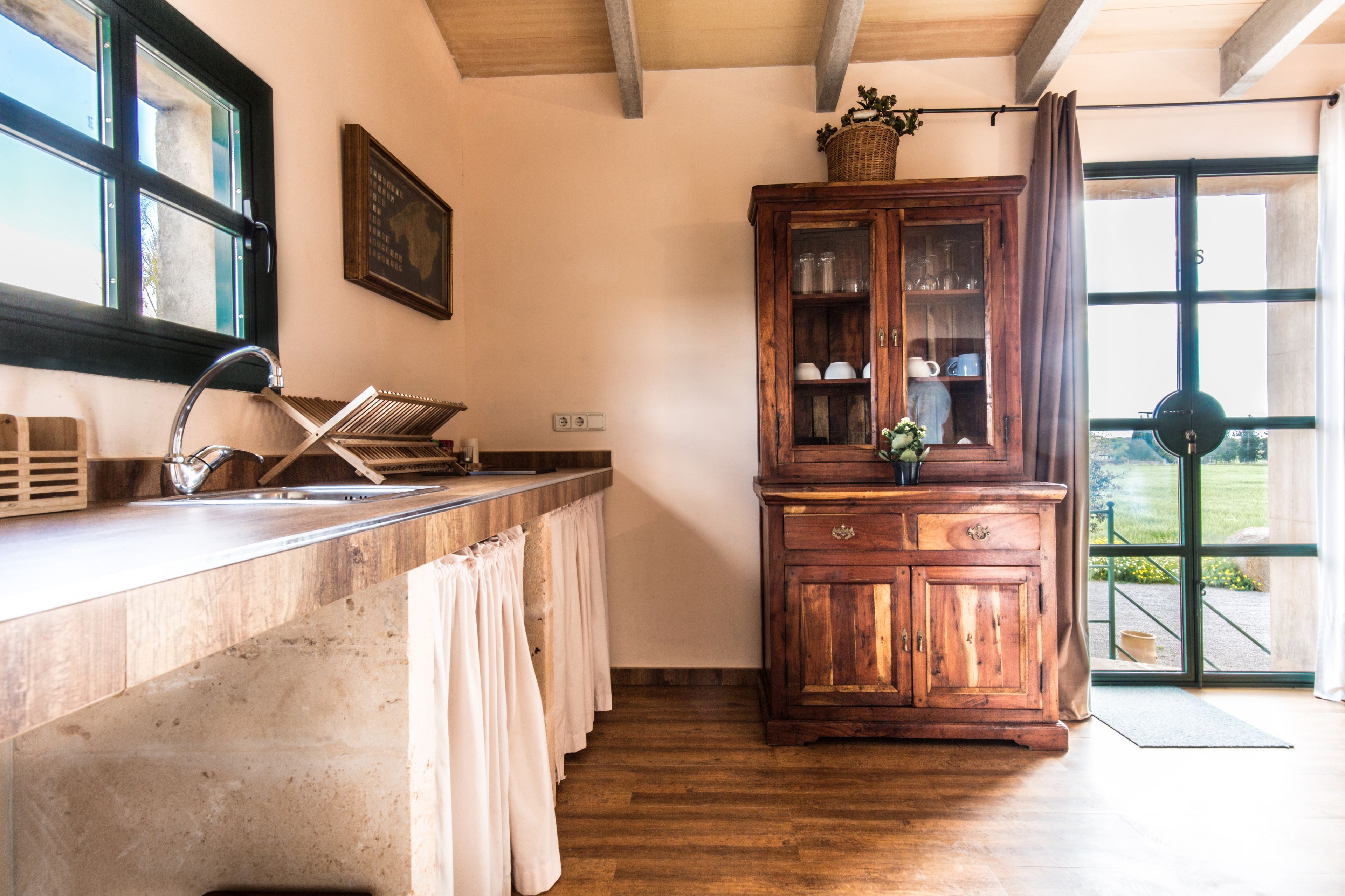 A kitchen with a wooden cabinet, a sink, and a window.