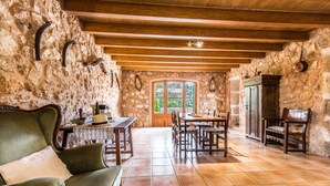 Un comedor rústico con paredes de piedra, muebles de madera y un ventanal grande.