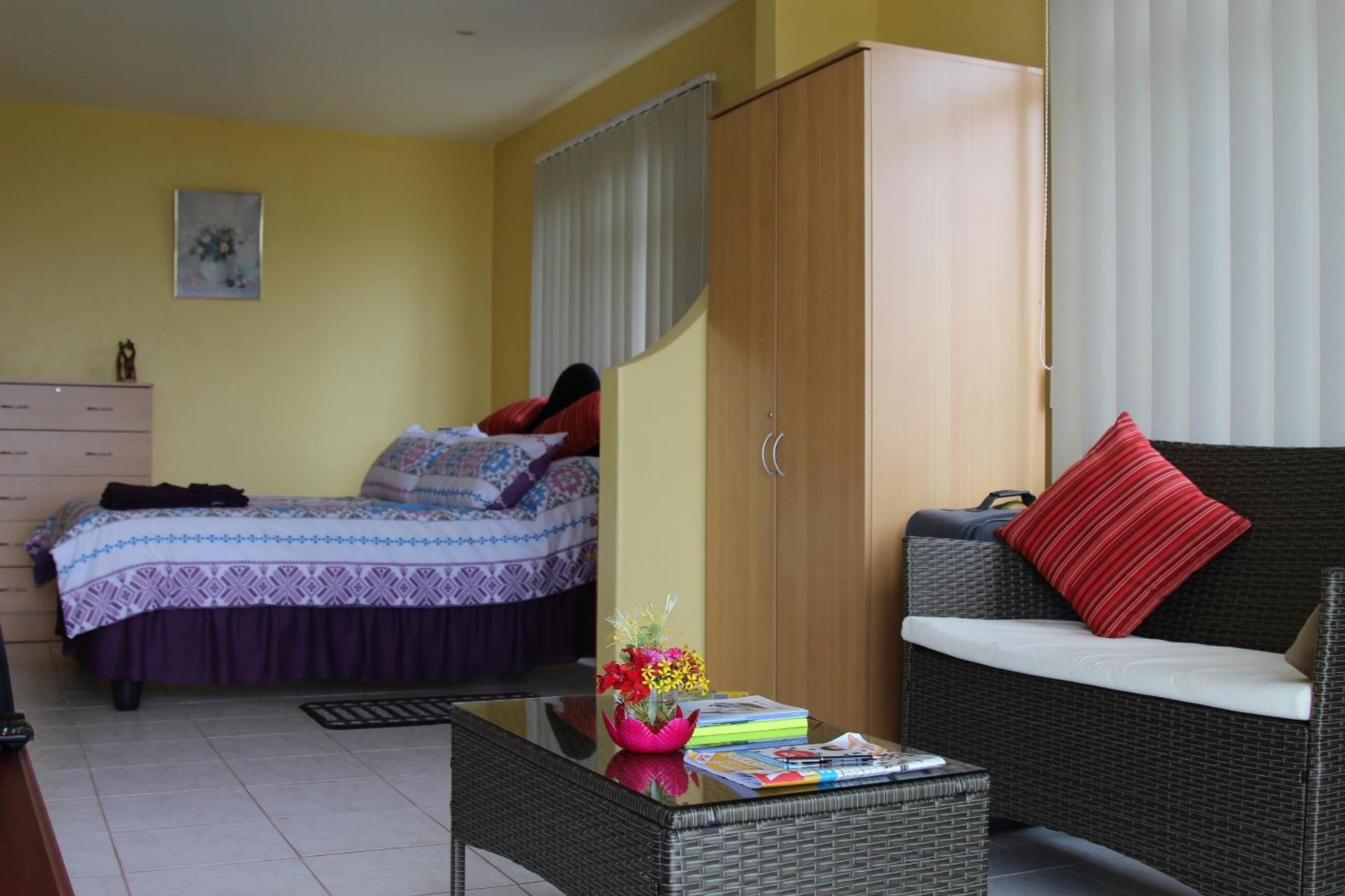 Une chambre à coucher avec un lit, une armoire, un canapé et une table basse.