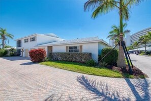 A modern two-story building with a paved driveway and a well-maintained lawn.