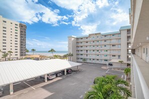 Ein Hotel mit Parkplatz, überdachtem Bereich und Blick auf den Strand.