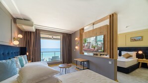 A hotel room with a large bed, a desk, a chair, a TV, and a view of the sea. - Marina Sunny Day Resort (Varna)
