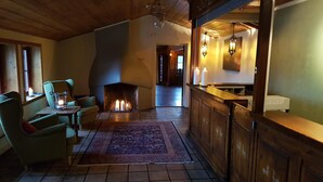 Una habitación acogedora con chimenea, barra y asientos.
