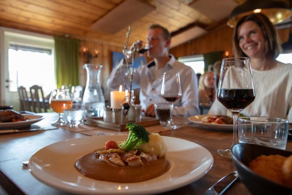 A dining table with plates of food, glasses of wine, and a candle.