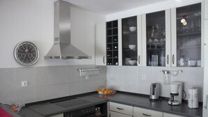 A modern kitchen with a stainless steel range hood, a built-in oven, and a coffee maker. - Apartment Marija (Kastela)