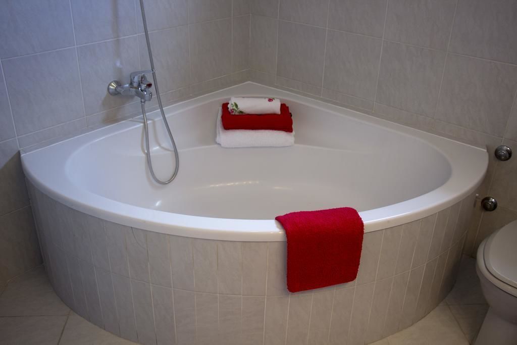 A bathroom with a bathtub, a toilet, and a shower area.