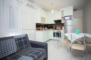 A compact living space with a kitchenette, a dining area, and a sofa. - Apartment Duje (Kastela)