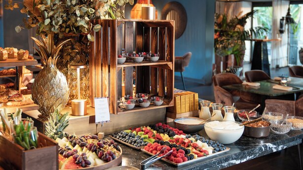 Een buffetgedeelte met verschillende soorten fruit en een decoratief middelpunt.