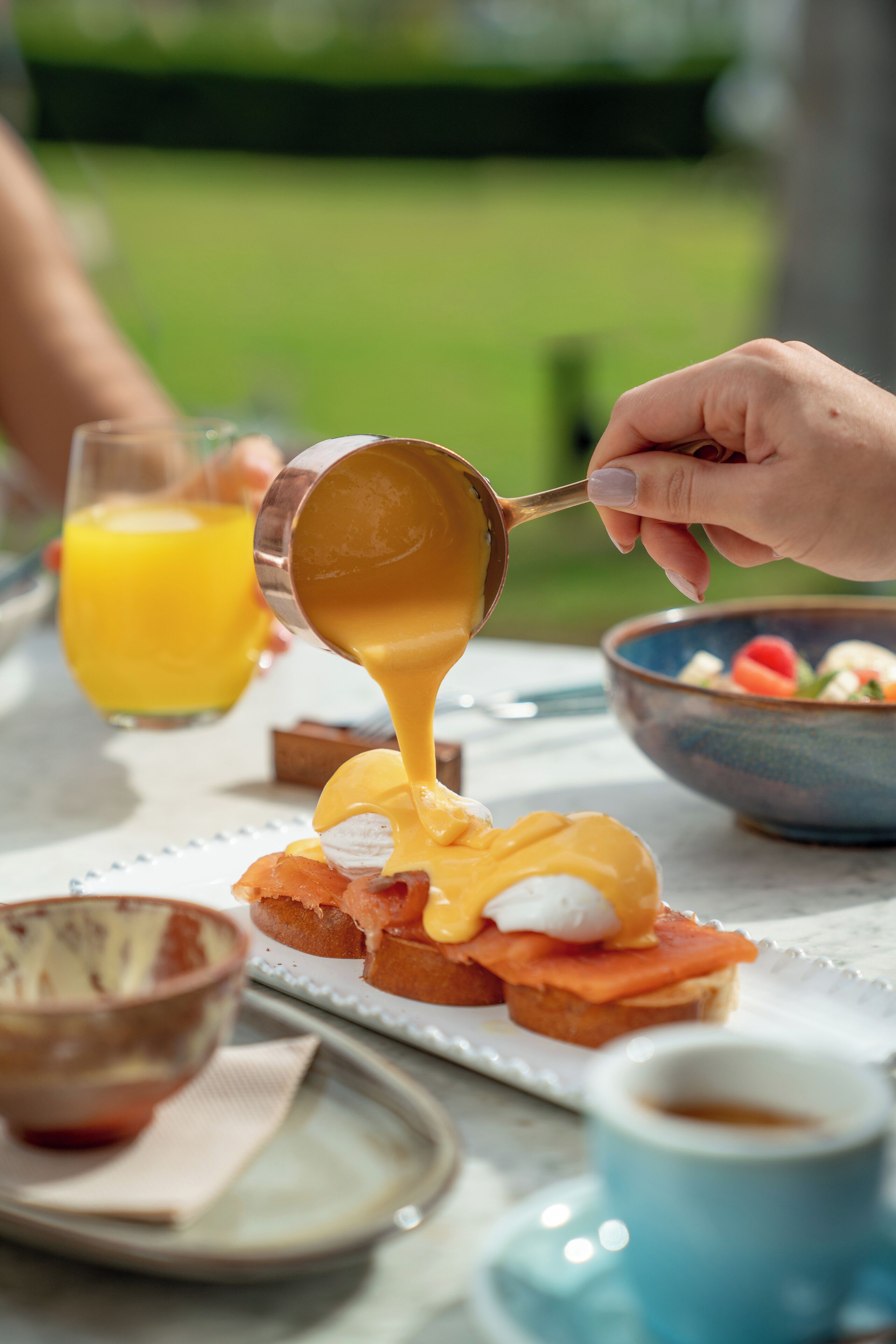 A breakfast setting with eggs, toast, and a bowl of fruit.