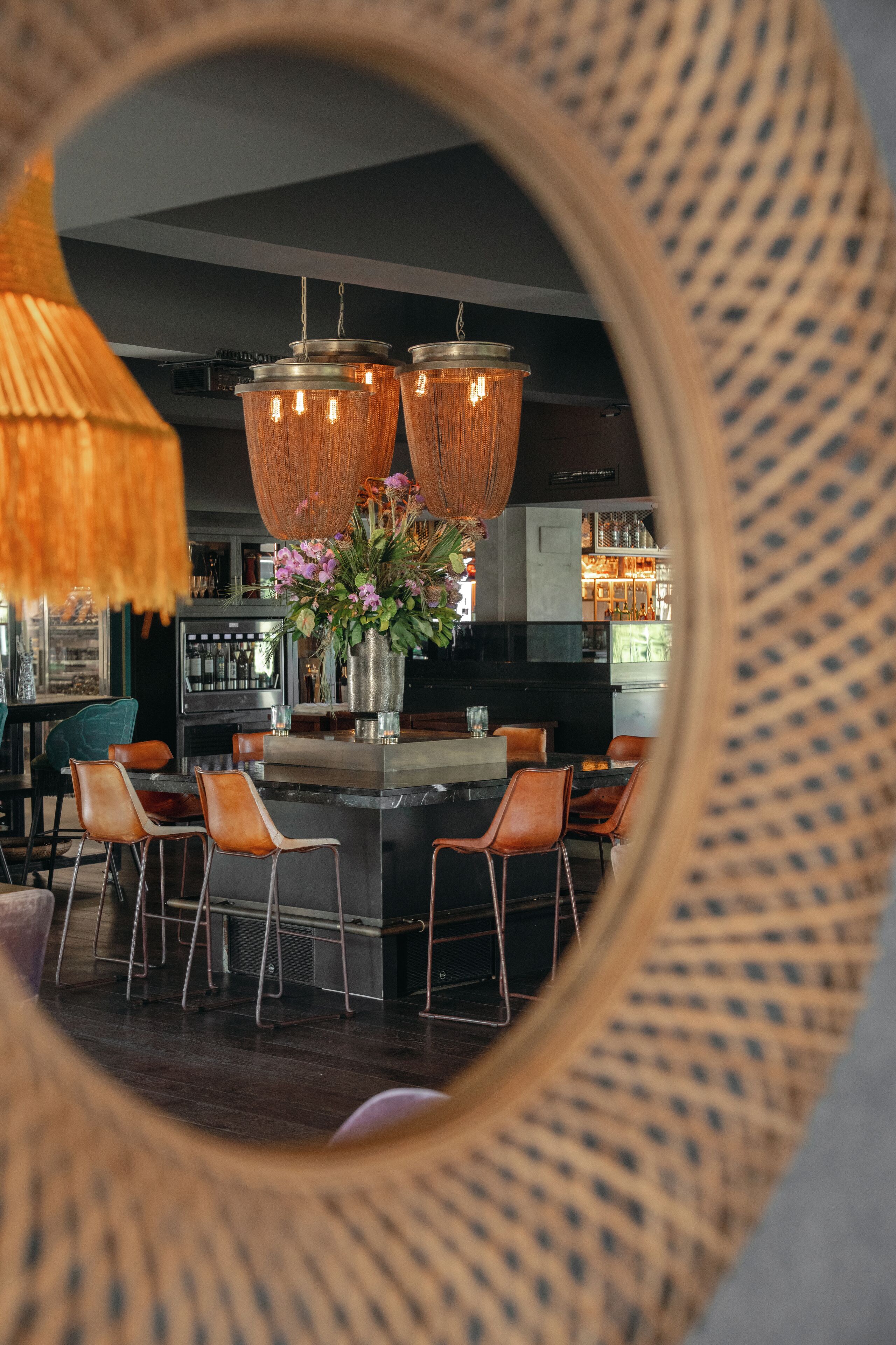 A modern kitchen with a central island, bar stools, and hanging pendant lights.