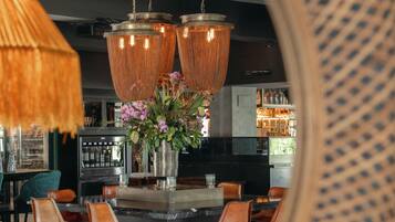 A modern kitchen with a central island, bar stools, and hanging pendant lights.