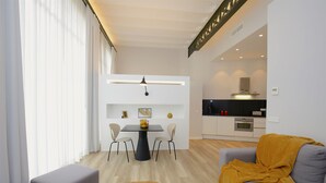 Un salon moderne avec un canapé, un pouf et une table à manger avec des chaises.