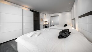 Ett modernt hotellrum med en stor säng, ett skrivbord och en spegel.