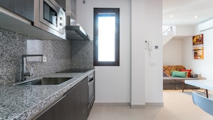 Una cucina moderna con piani di lavoro in granito, elettrodomestici in acciaio inox e forno integrato.