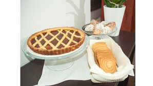 A pie on a glass stand, a plate of pastries, and a rolled pastry on a cloth. - Da Molly (Rome)