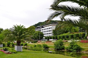 Un hotel de diseño moderno, un jardín ajardinado y un estanque.