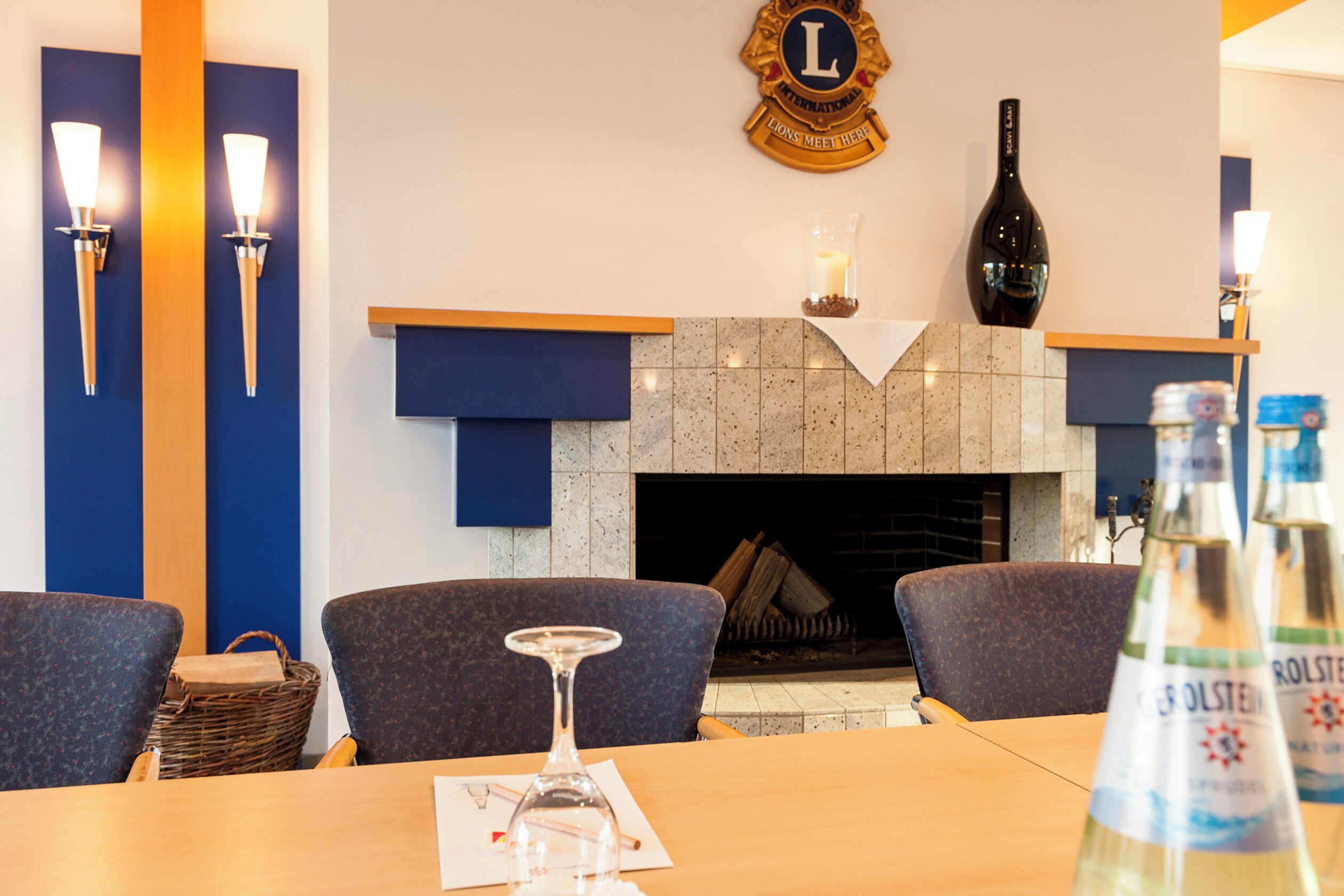 Een hotellobby met een open haard, een zithoek en een receptiebalie.