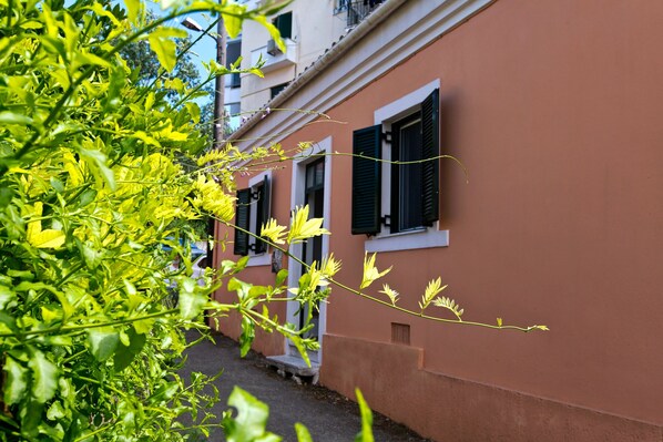 Une rue étroite bordée d’immeubles dotés de balcons et de volets.