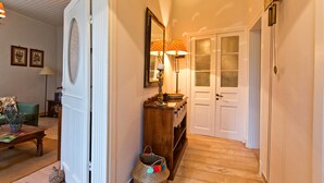 A hallway with a wooden floor, a mirror, a lamp, and a door with frosted glass panels. - Casa Paleopolis near Royal Baths MonRepo (Corfu)