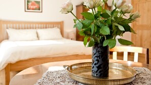 Un dormitorio con cama, mesita de noche con un florero y cabecero de madera.