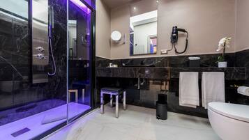 A modern bathroom with a glass-enclosed shower, a vanity with a mirror, and a toilet.