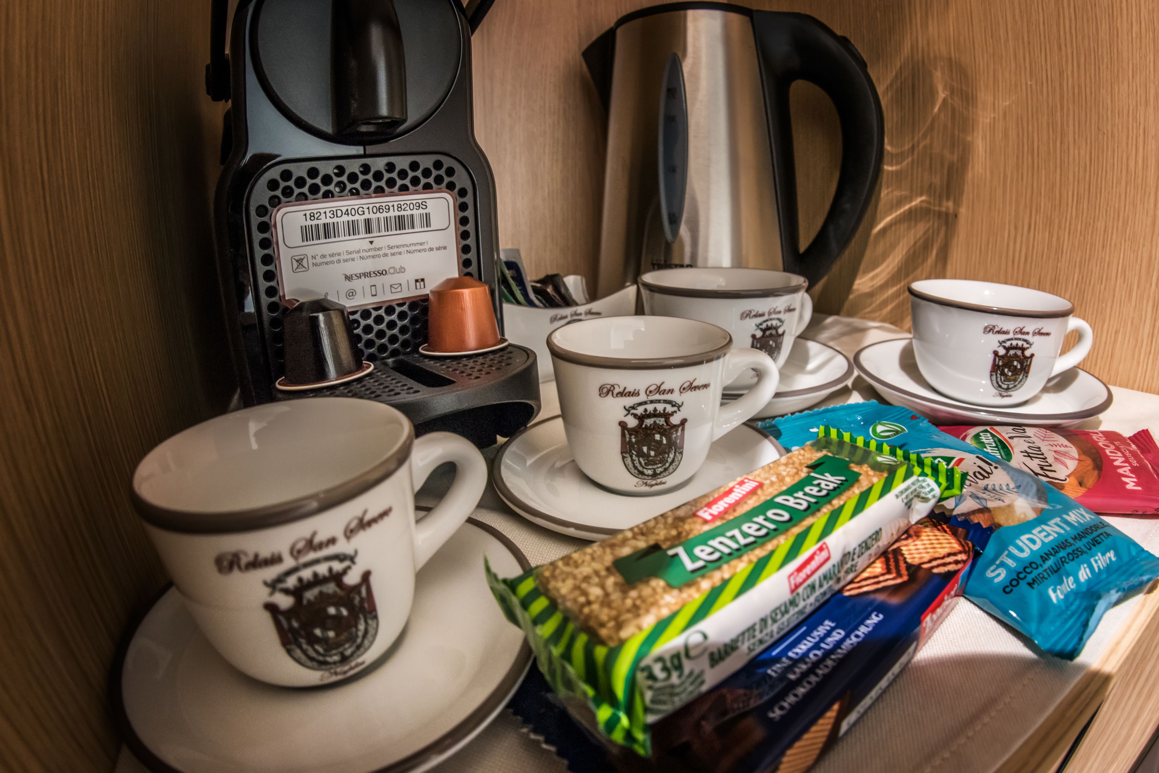 Eine Kaffeestation mit Kaffeemaschine, Tassen und Snacks.