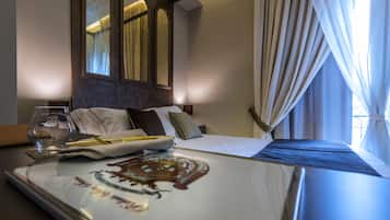 A hotel room with a neatly made bed, a bedside table with a glass, and a framed picture.
