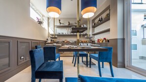 Una cocina moderna con sillas azules, una mesa de comedor y lámparas colgantes.