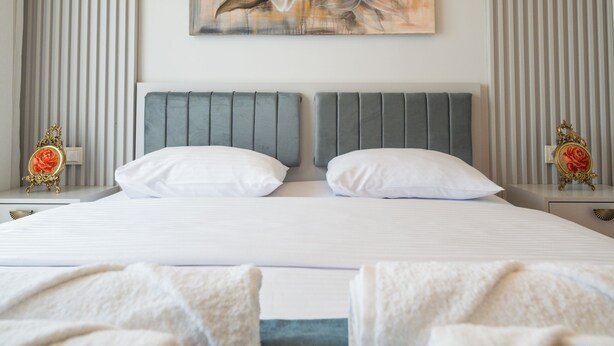 Une chambre d’hôtel moderne avec un grand lit, un tableau décoratif et une vue sur la ville.