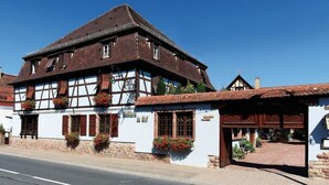 A traditional half-timbered building with a steep roof, large windows, and flower boxes. - Hotel Restaurant & Spa - Le Cerf (Marlenheim)