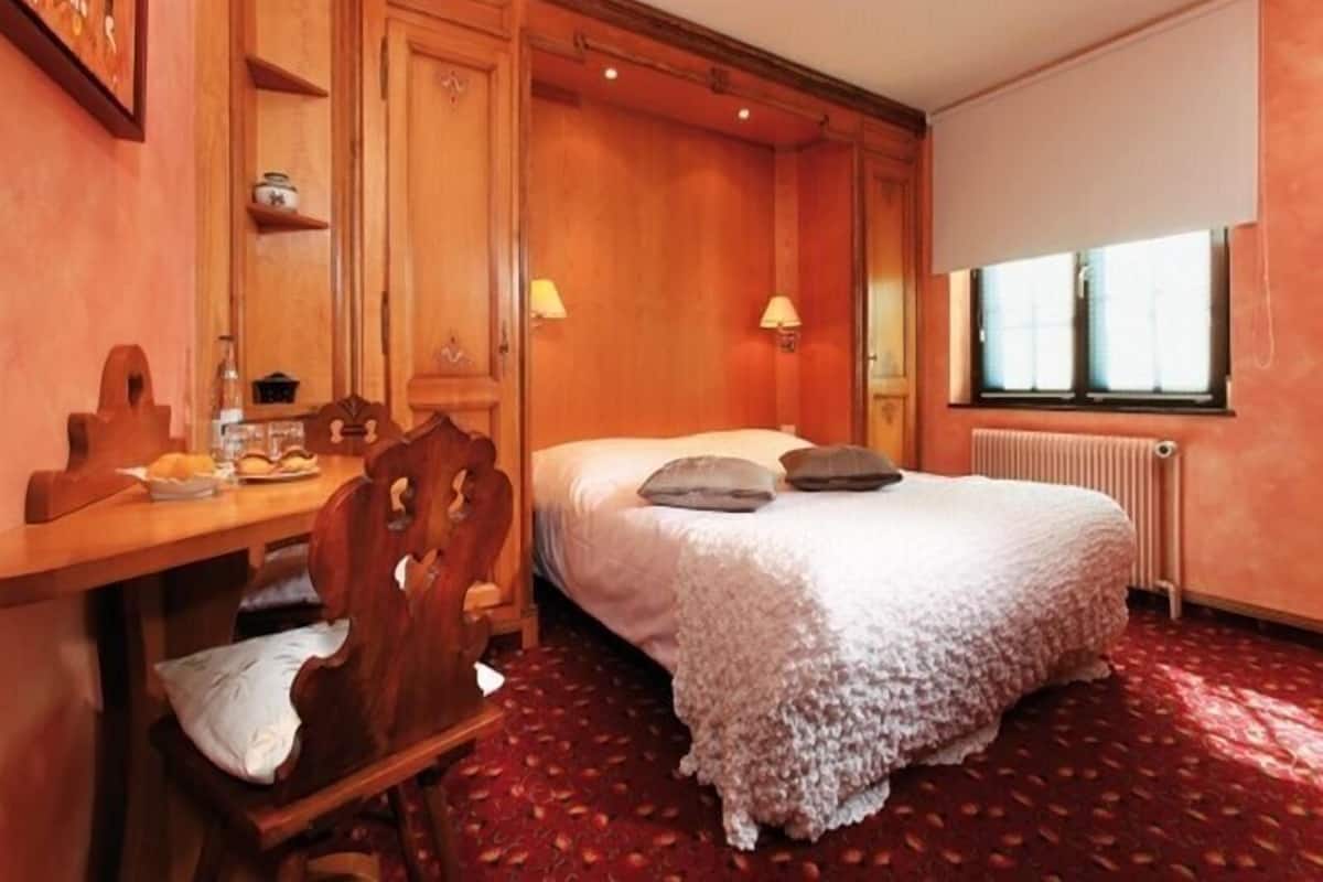Un dormitorio acogedor con una cama de madera, un escritorio y una silla.