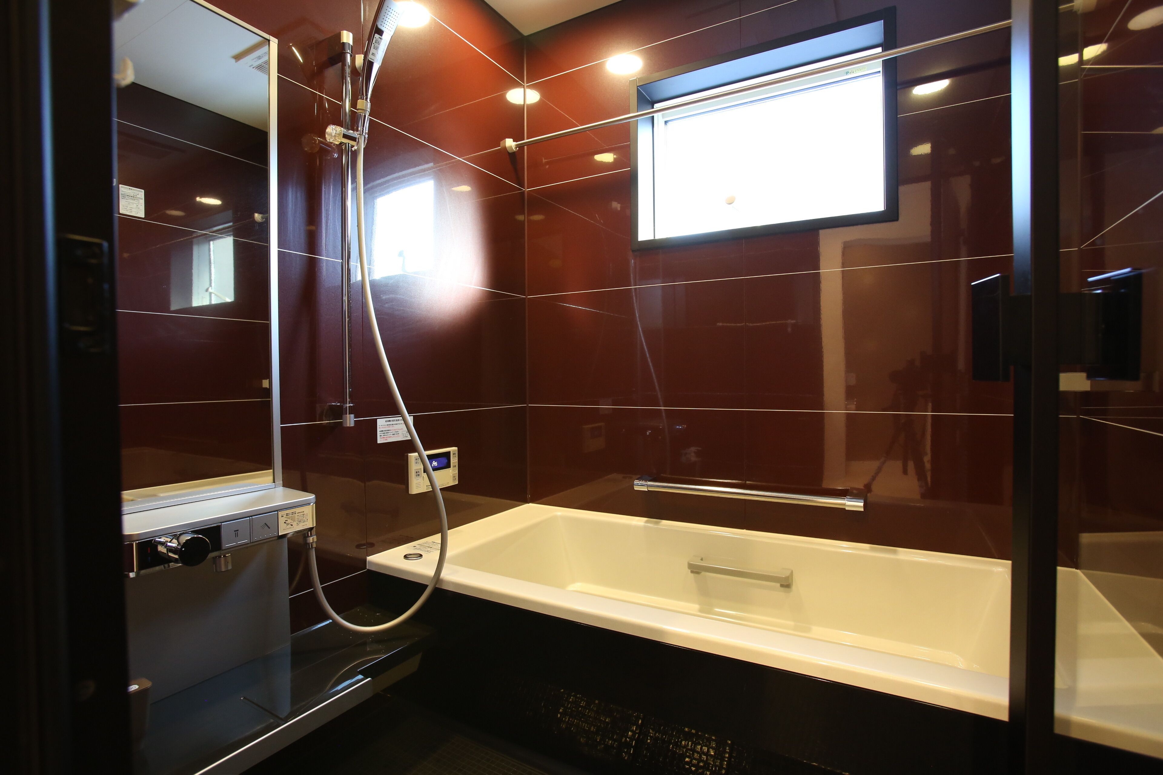 A modern bathroom with a glass-enclosed shower, a white bathtub, and a mirror.