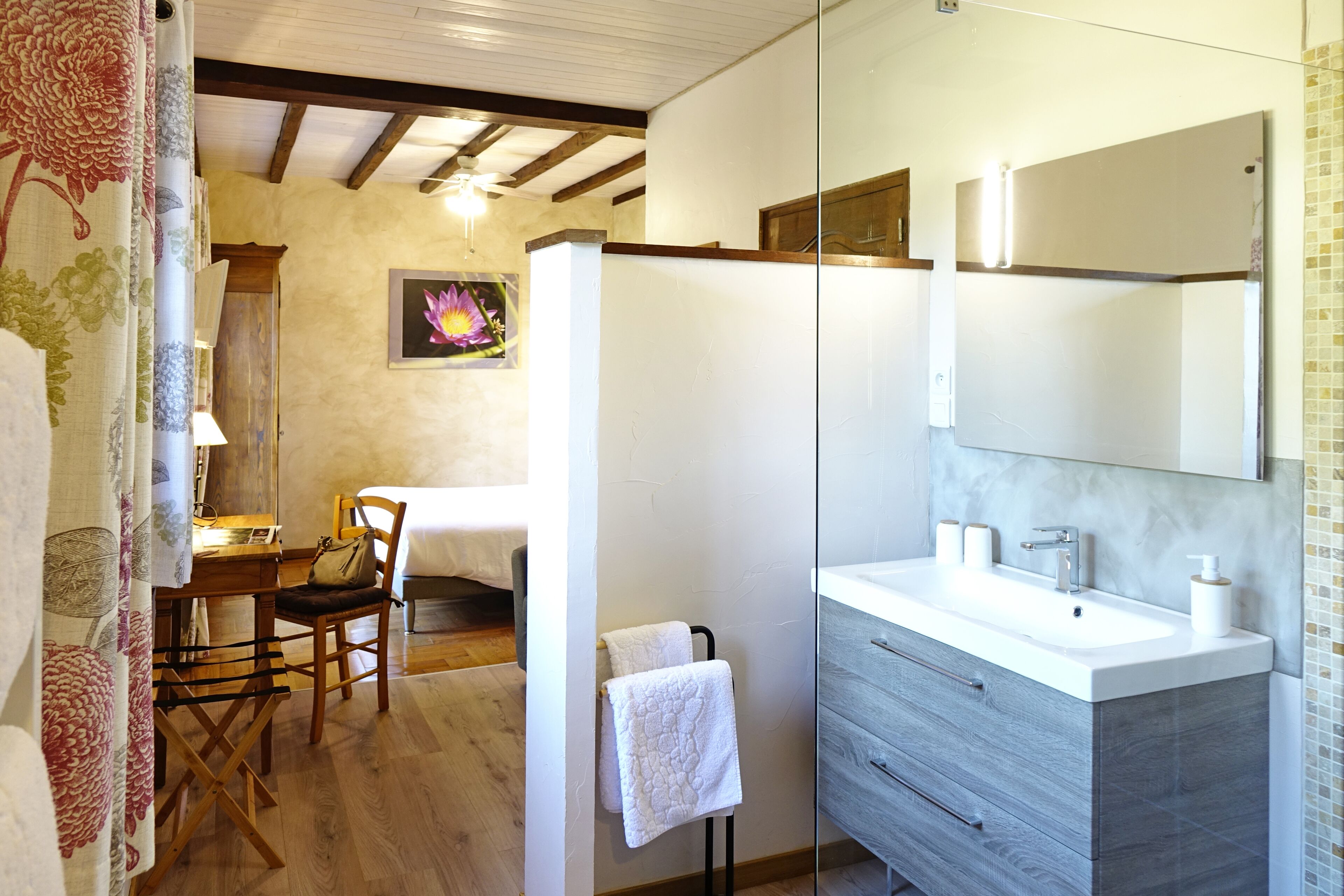 A bathroom with a large mirror, a sink, and a towel rack.