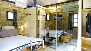 A bedroom with a bed, bedside table, lamp, and a wooden chest. - Au Pre des Sources (Campagne)